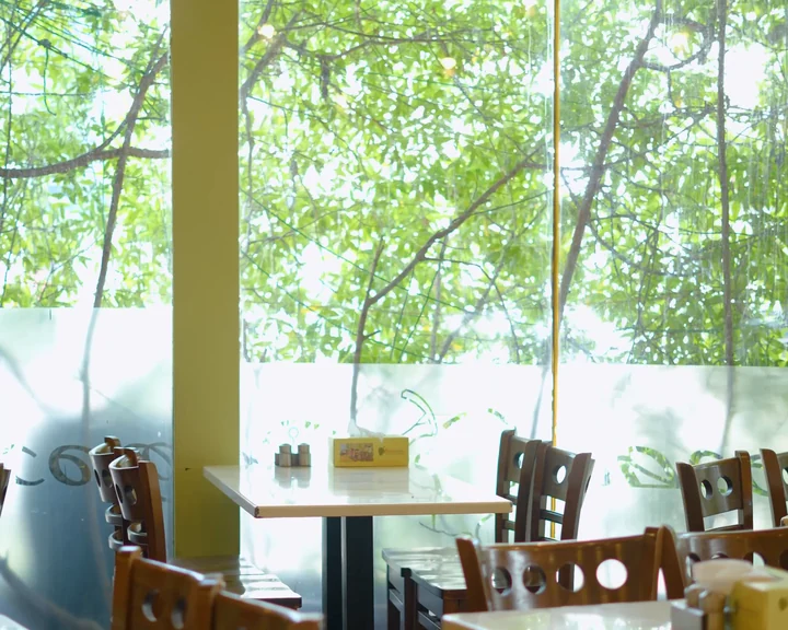 Dining room with hanging greenery and garden windows at Aaraamam Oud Metha